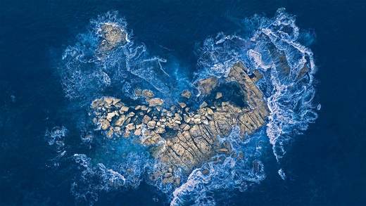 海浪冲击着悉尼海岸的一个心形岩石岛，澳大利亚 (© Kristian Bell/Getty Images)_必应壁纸