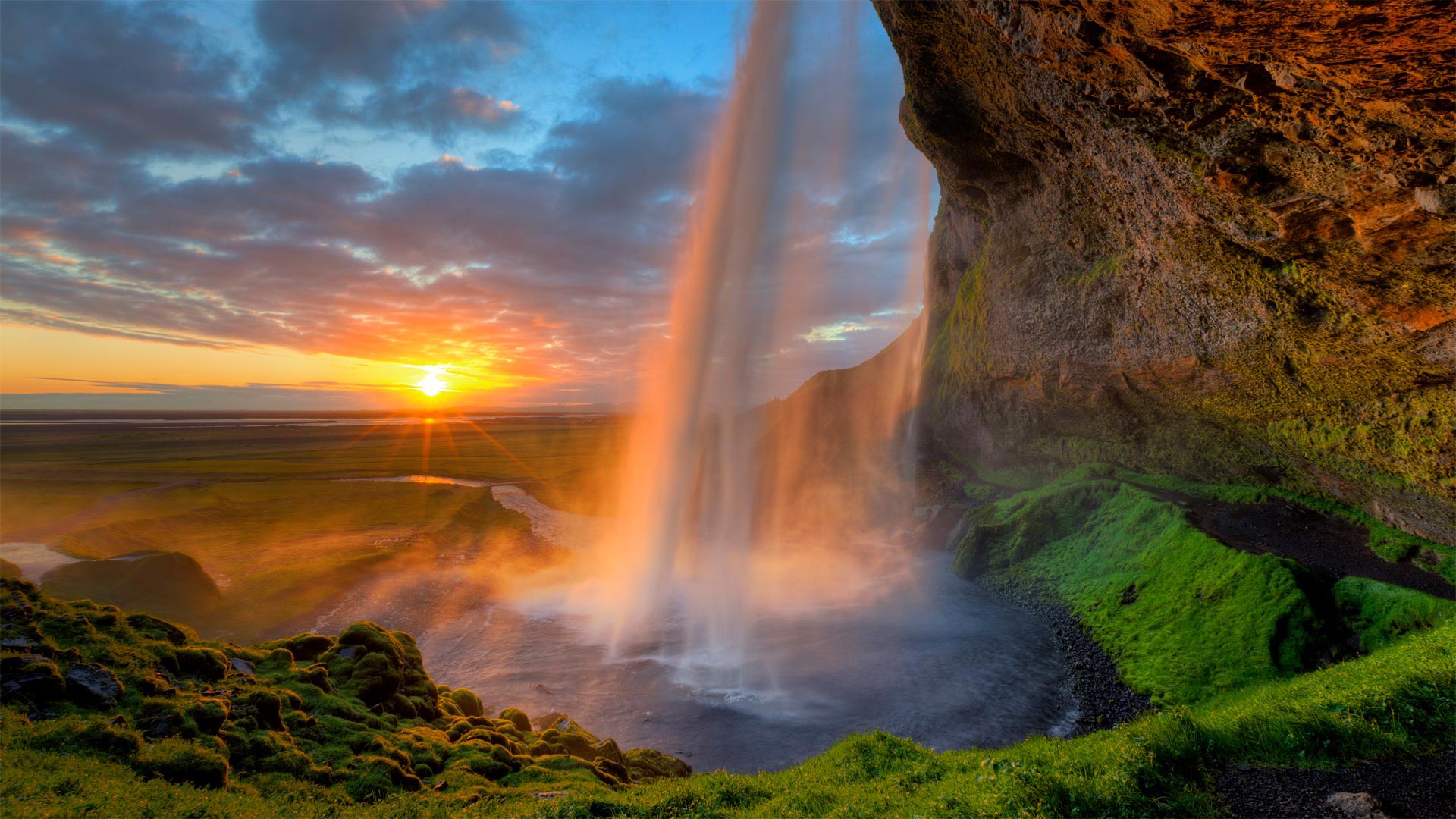 必应壁纸:塞里雅兰瀑布后的午夜太阳，冰岛南海岸附近 (© Tom Mackie/plainpicture)