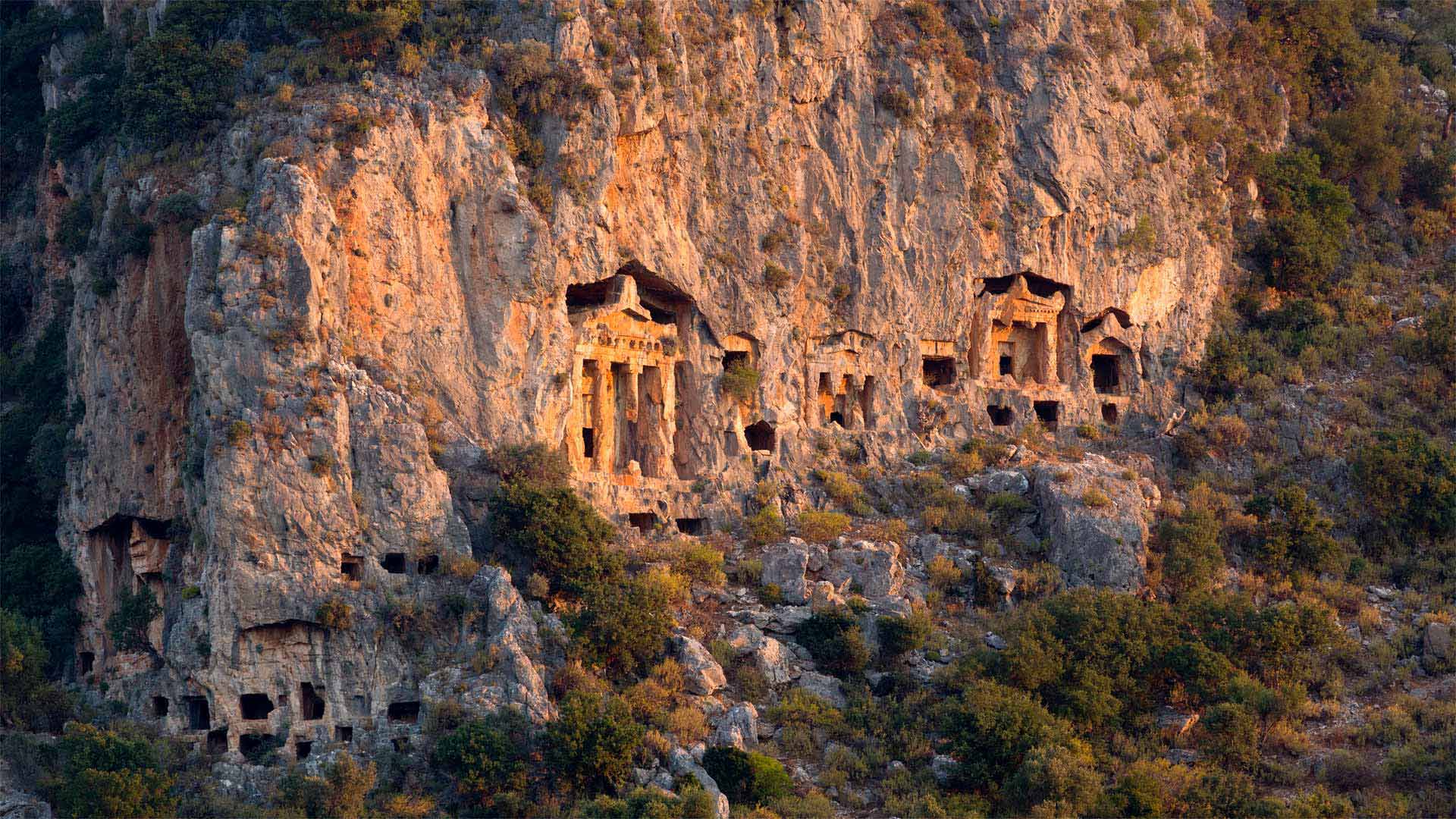 必应壁纸:悬崖上雕刻的古老岩石墓葬，土耳其达利安附近