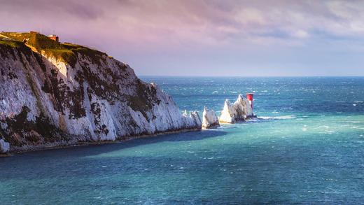 英格兰怀特岛上的尼德尔斯白垩岩石和19世纪的灯塔。 (© CBCK Christine/iStock/Getty Images Plus)_必应壁纸
